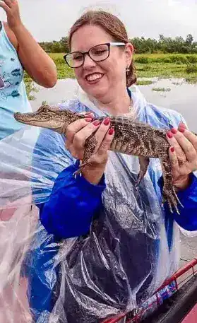 Tourist holding baby alligator on airboat tour