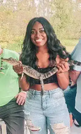 Guest posing with baby alligator